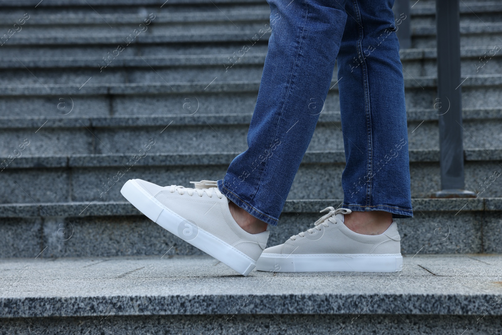 Photo of Man wearing pair of stylish sneakers outdoors, closeup