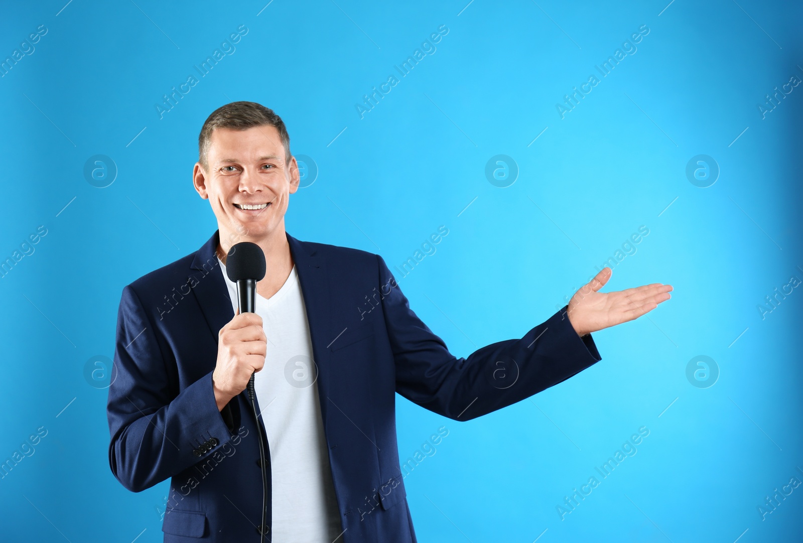 Photo of Male journalist with microphone on blue background