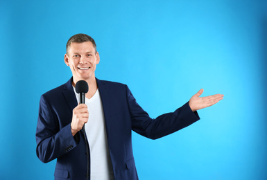 Male journalist with microphone on blue background