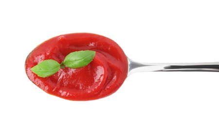 Spoon with tasty ketchup and basil isolated on white, top view