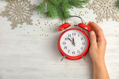 Photo of Woman with alarm clock at table, top view. Christmas countdown