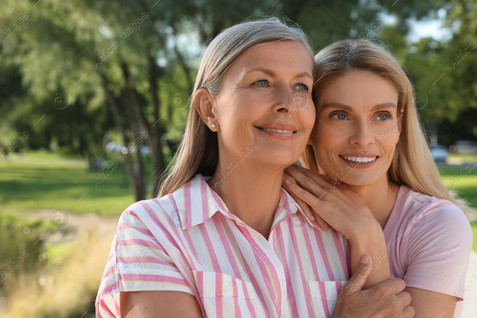 Photo of Family portrait of mother and daughter outdoors. Space for text