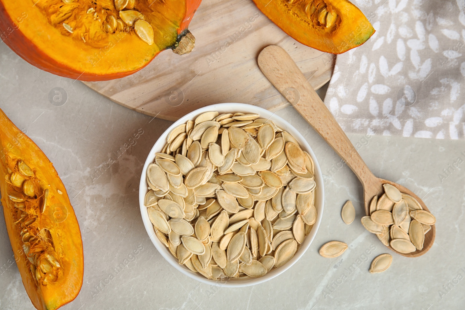 Photo of Flat lay composition with raw pumpkin seeds on light grey marble table