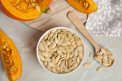 Photo of Flat lay composition with raw pumpkin seeds on light grey marble table