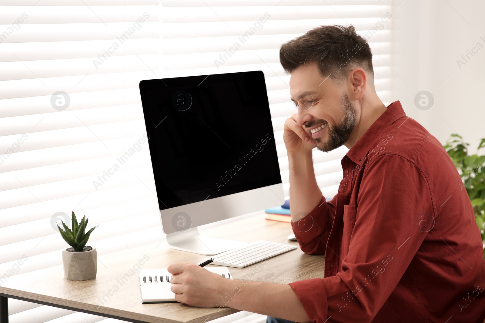 Photo of Online translation course. Man writing near computer indoors