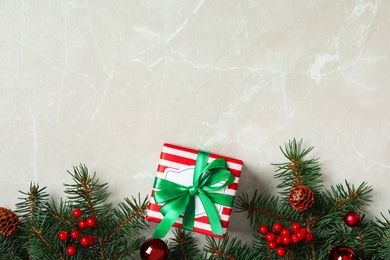 Photo of Christmas gift box with green bow and festive decor on light table, flat lay. Space for text