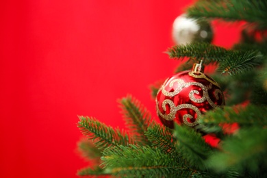 Beautifully decorated Christmas tree against color background, closeup