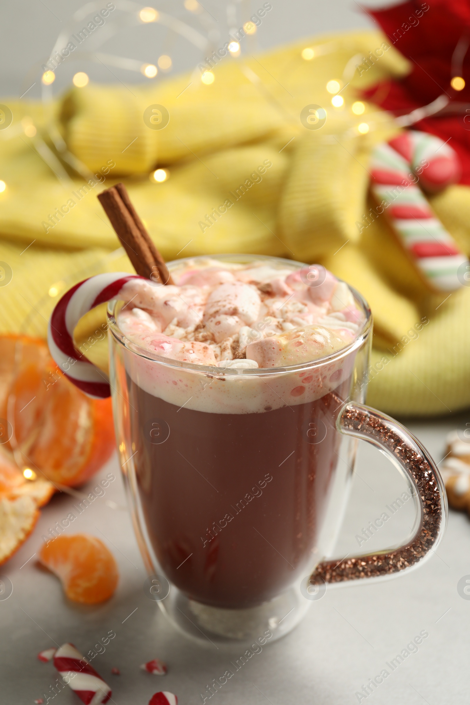 Photo of Composition with delicious marshmallow drink, festive items and yellow sweater on light table