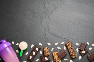 Photo of Different energy bars, almond flakes, protein cocktail and powder on black table, flat lay. Space for text