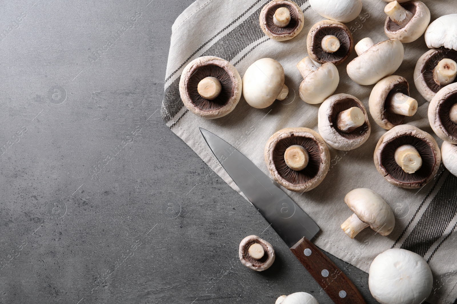 Photo of Flat lay composition with fresh champignon mushrooms and space for text on grey background