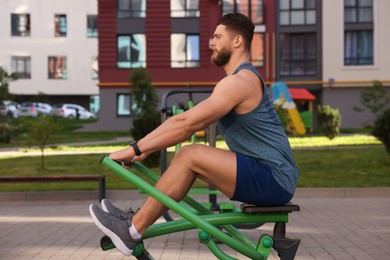 Man training on rowing machine at outdoor gym