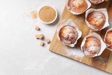 Photo of Delicious muffins on light table, flat lay. Space for text