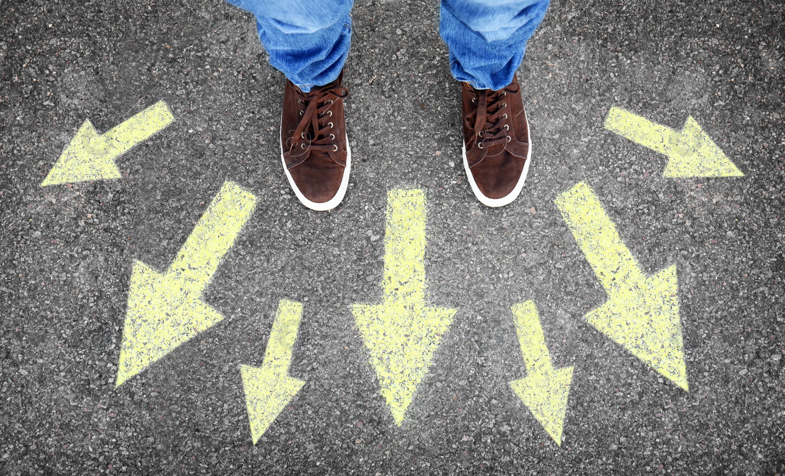 Image of Man standing on road near arrows, top view 