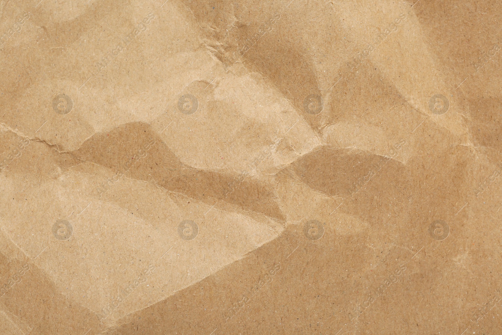 Photo of Crumpled kraft notebook sheet as background, top view