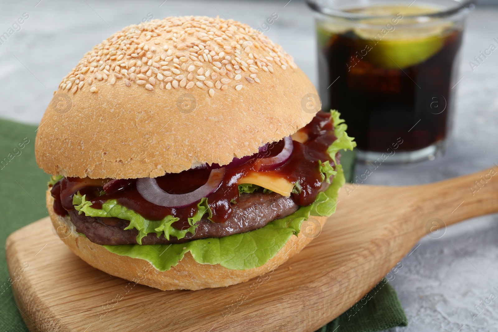 Photo of Board with delicious cheeseburger on table, closeup