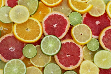 Photo of Different citrus fruits as background, top view