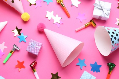 Flat lay composition with party hats on pink background