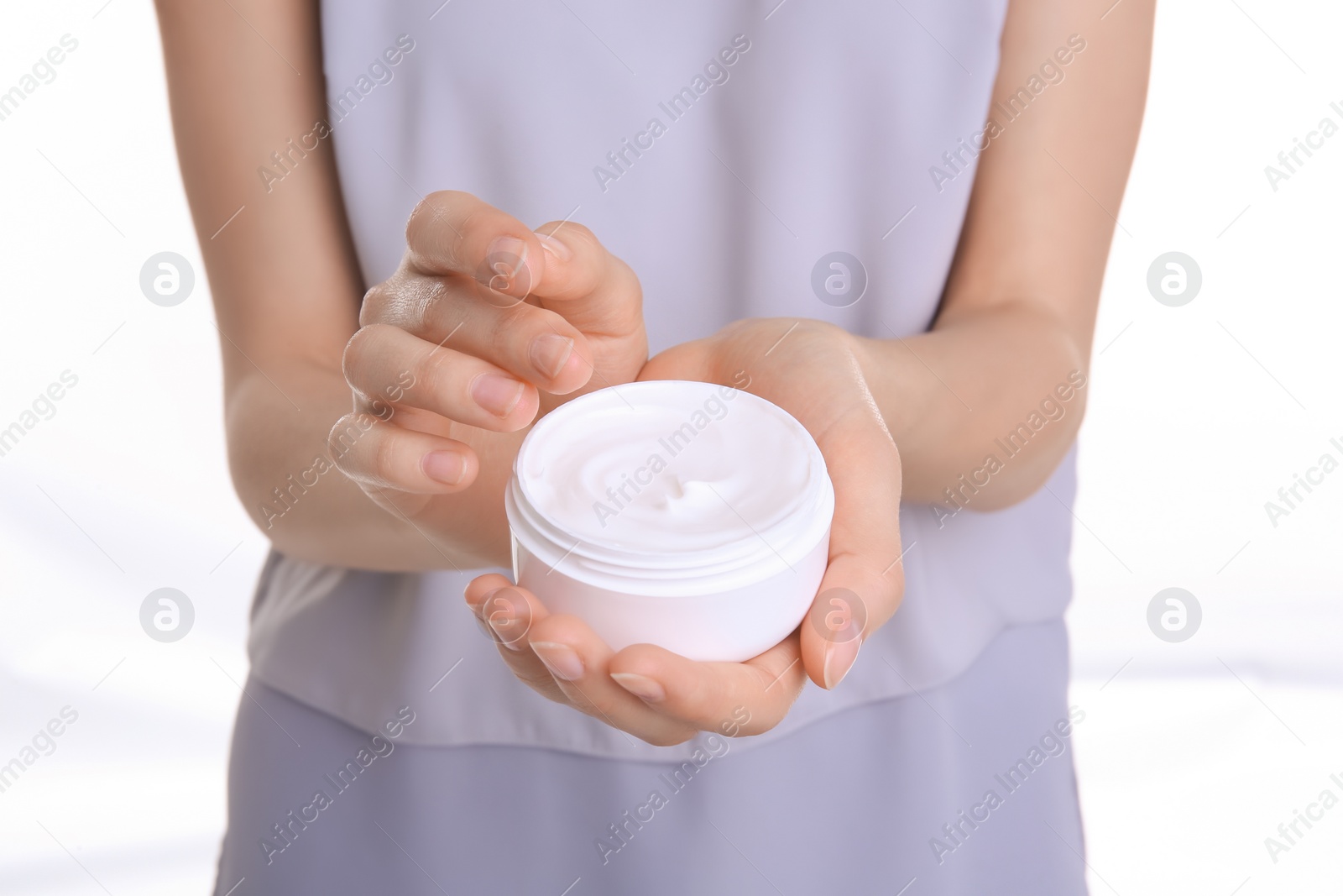 Photo of Young woman holding jar with hand cream, closeup