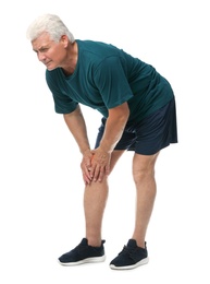 Full length portrait of senior man having knee problems on white background