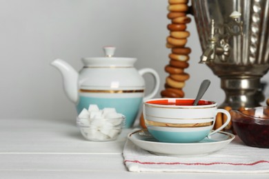 Composition with delicious ring shaped Sushki (dry bagels) and tea on white wooden table indoors, space for text