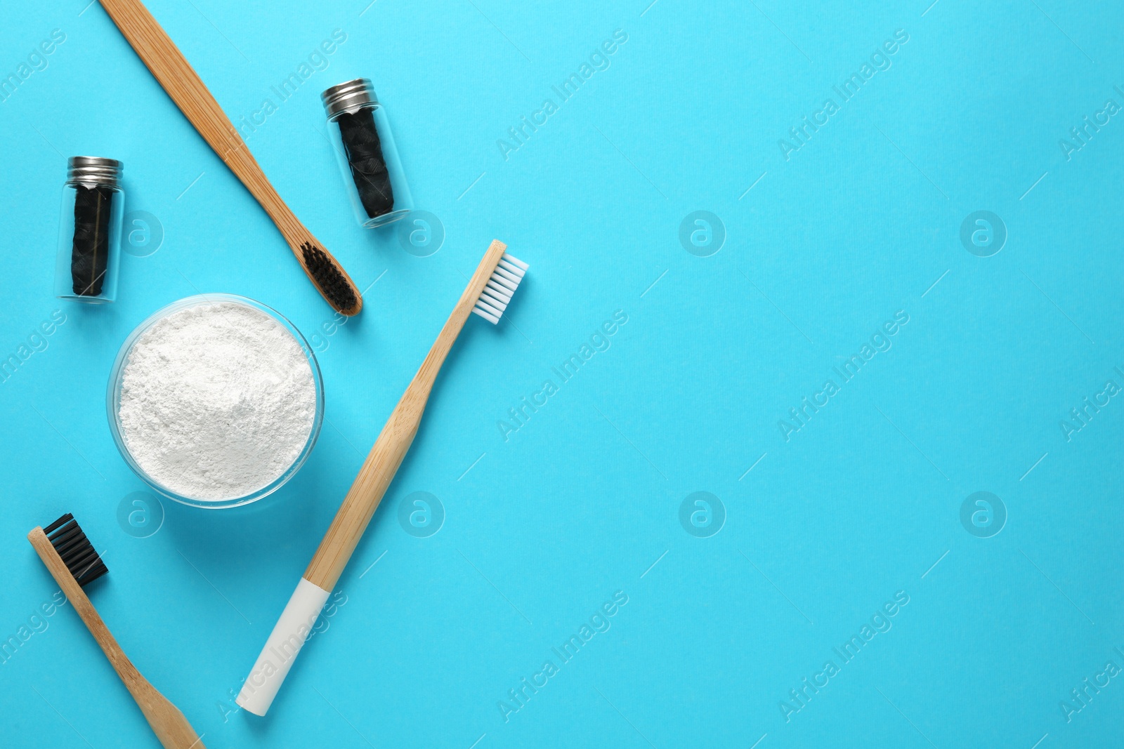 Photo of Bowl of tooth powder, brushes and dental flosses on turquoise background, flat lay. Space for text