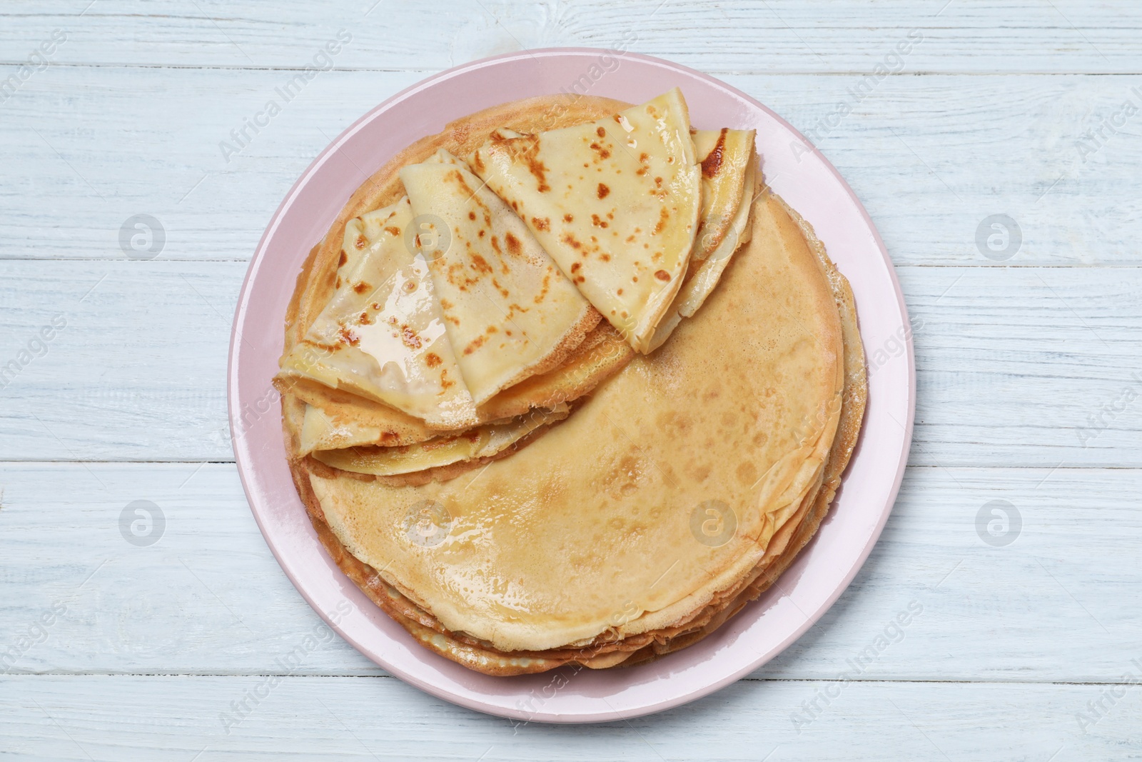 Photo of Delicious crepes on white wooden table, top view