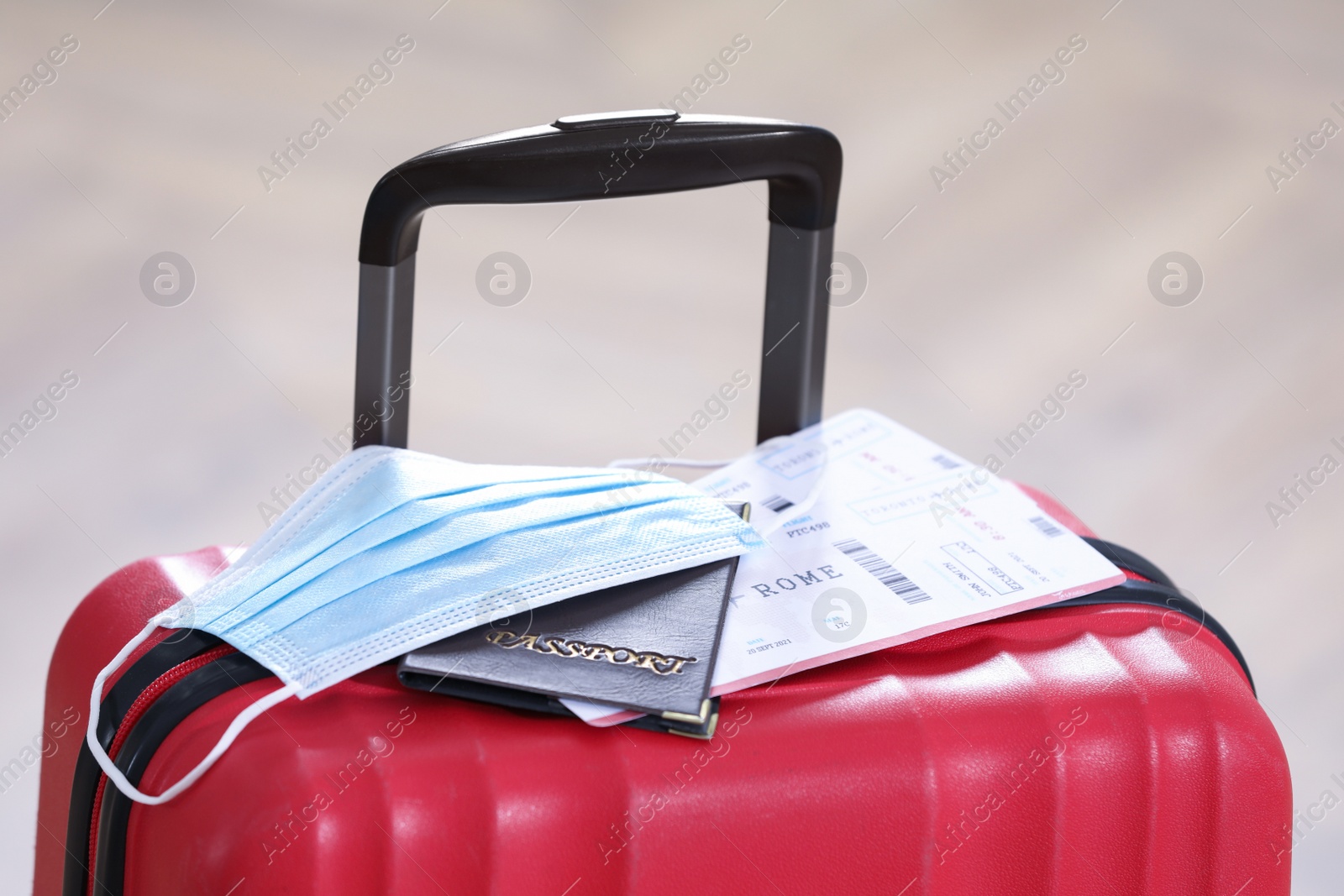 Photo of Passport, protective mask and tickets on red suitcase. Travel during quarantine