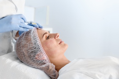 Photo of Woman undergoing face biorevitalization procedure in salon. Cosmetic treatment