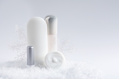 Photo of Set of cosmetic products and decorative snow on white background, space for text. Winter care