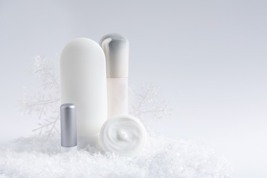 Set of cosmetic products and decorative snow on white background, space for text. Winter care