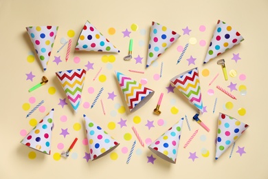 Flat lay composition with party cones and confetti on beige background