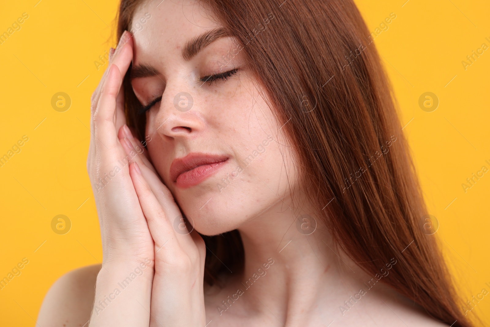 Photo of Portrait of beautiful woman with freckles on yellow background, closeup