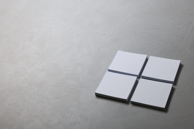 Photo of Blank paper sheets on grey textured table, closeup. Mockup for design