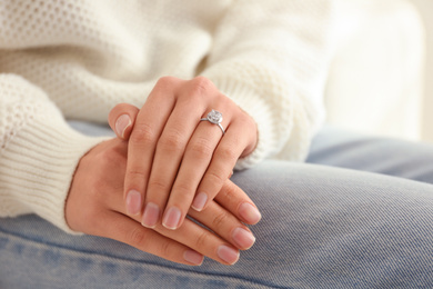 Young woman wearing beautiful engagement ring, closeup