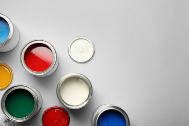 Photo of Open paint cans and space for text on grey background, top view
