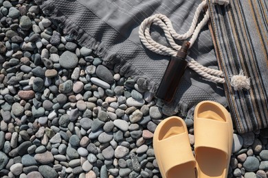 Photo of Stylish bag, yellow flip flops and spray on stones outdoors, flat lay. Space for text