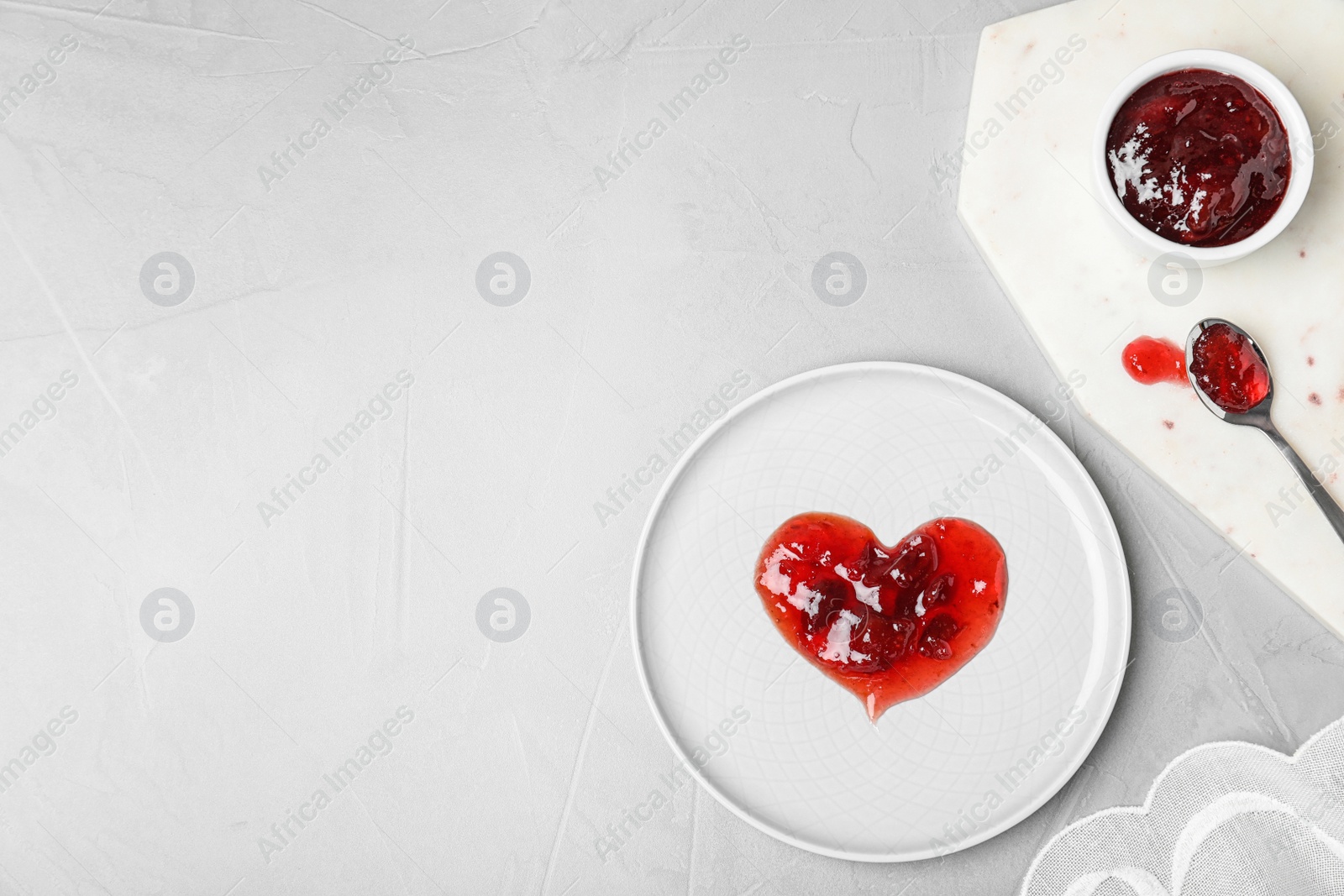 Photo of Flat lay composition with tableware, heart made of jam and space for text on light background