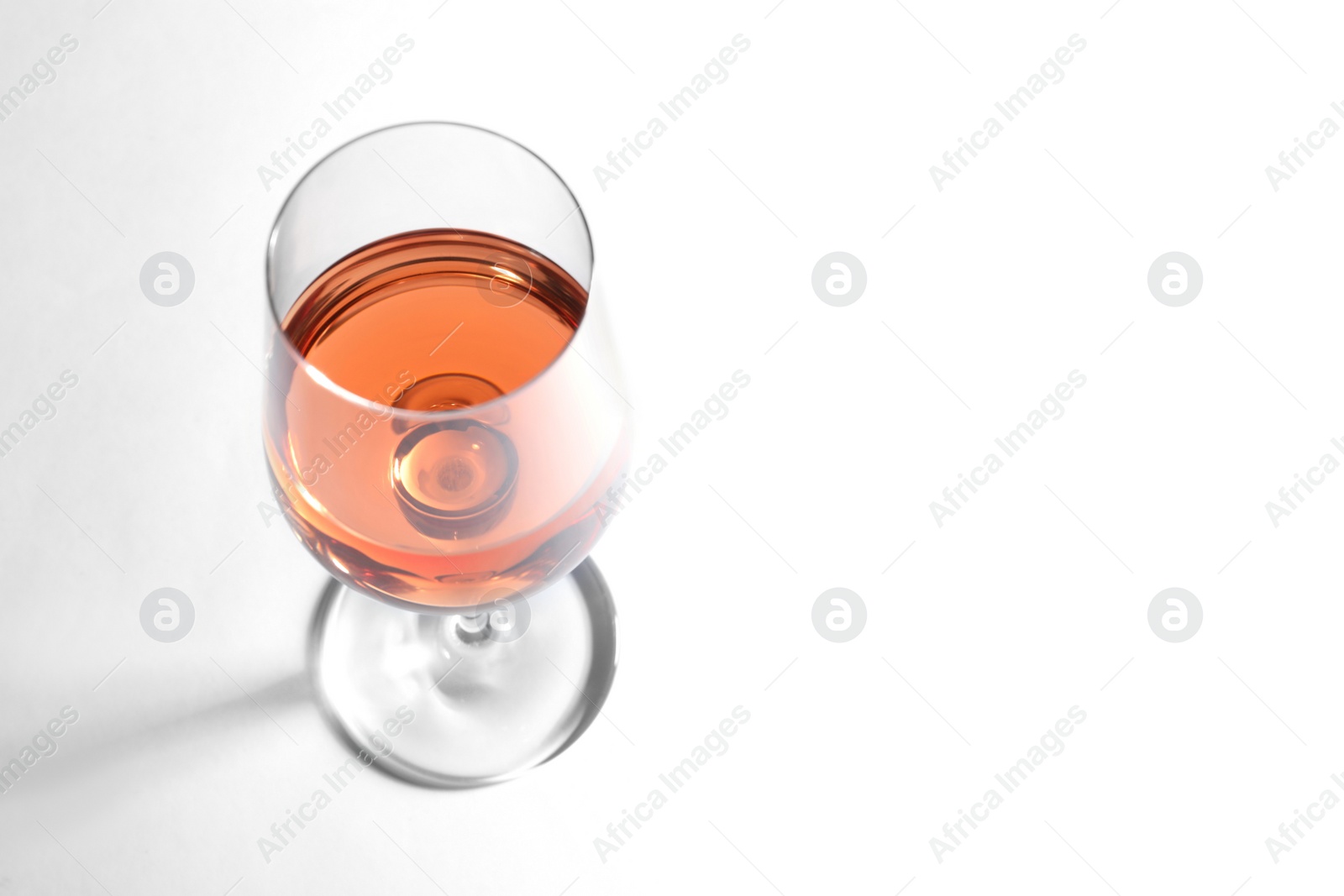 Photo of Glass of delicious wine on white background, above view