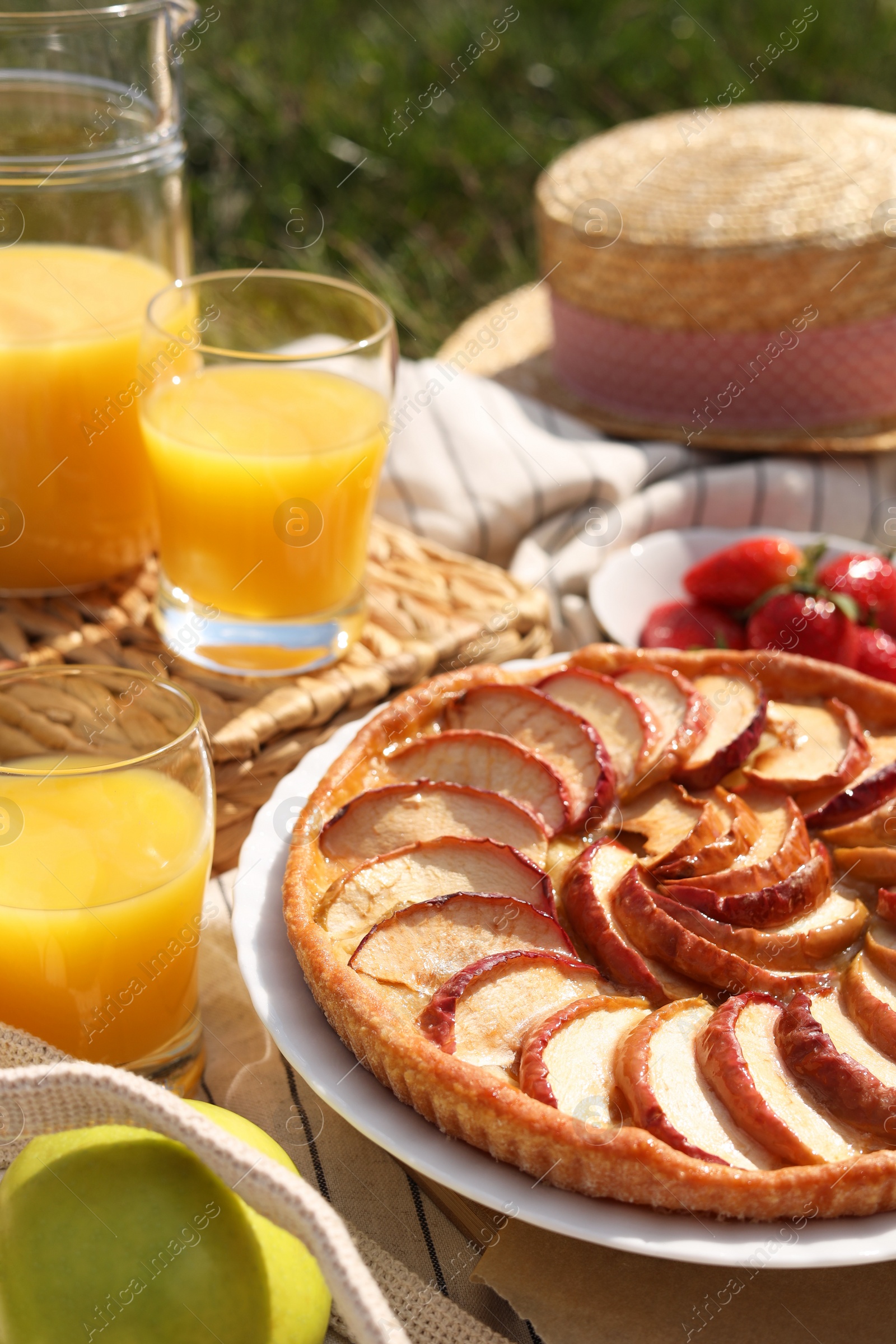 Photo of Blanket with different products outdoors, closeup. Summer picnic