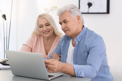 Mature couple thinking over pension payment at home