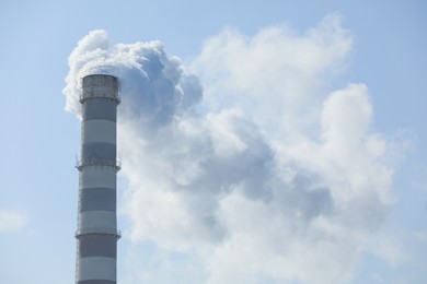 Photo of Polluting air with smoke from industrial chimney outdoors. CO2 emissions