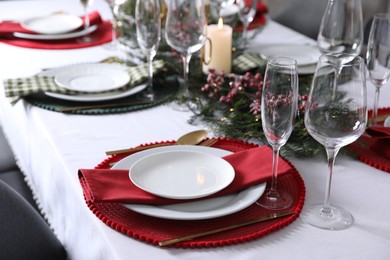 Photo of Christmas table setting with festive decor and dishware