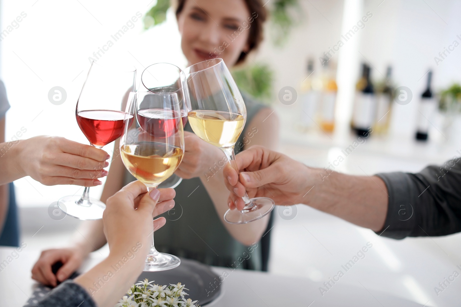 Photo of Young people with glasses of delicious wine at table