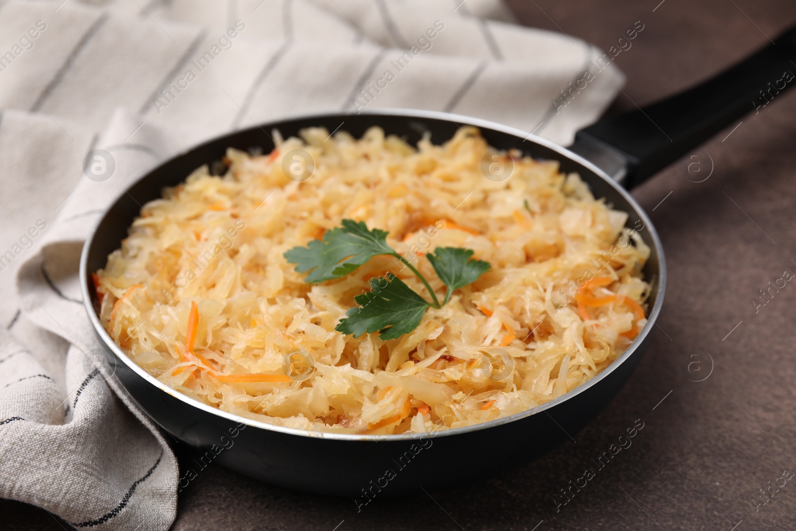 Photo of Frying pan with sauerkraut on brown table