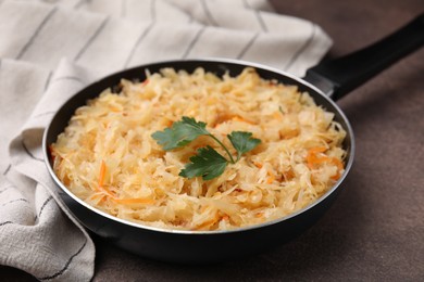 Frying pan with sauerkraut on brown table