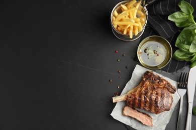 Image of Tasty grilled steak served on black table, flat lay. Space for text