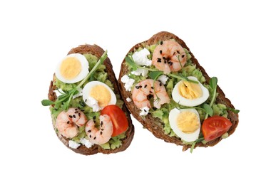 Delicious sandwiches with guacamole, shrimps and eggs on white background, top view
