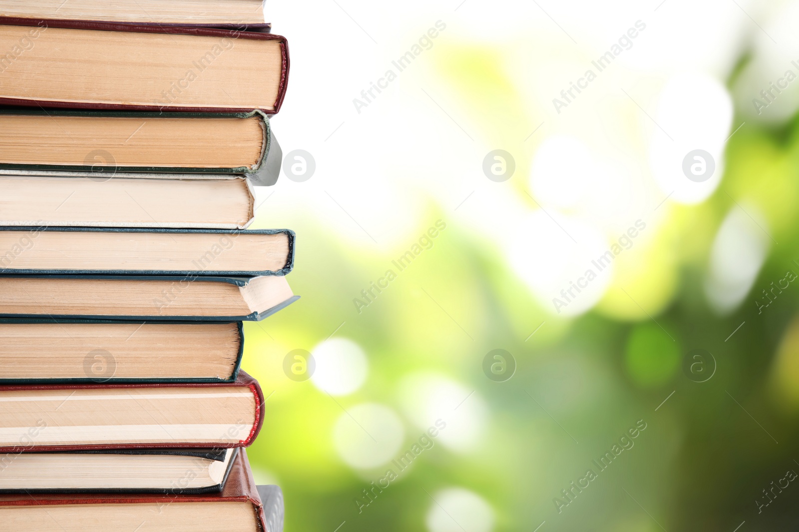 Image of Collection of different books on blurred green background, space for text