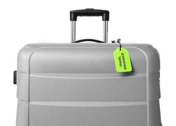 Photo of Grey suitcase with TRAVEL INSURANCE label on white background