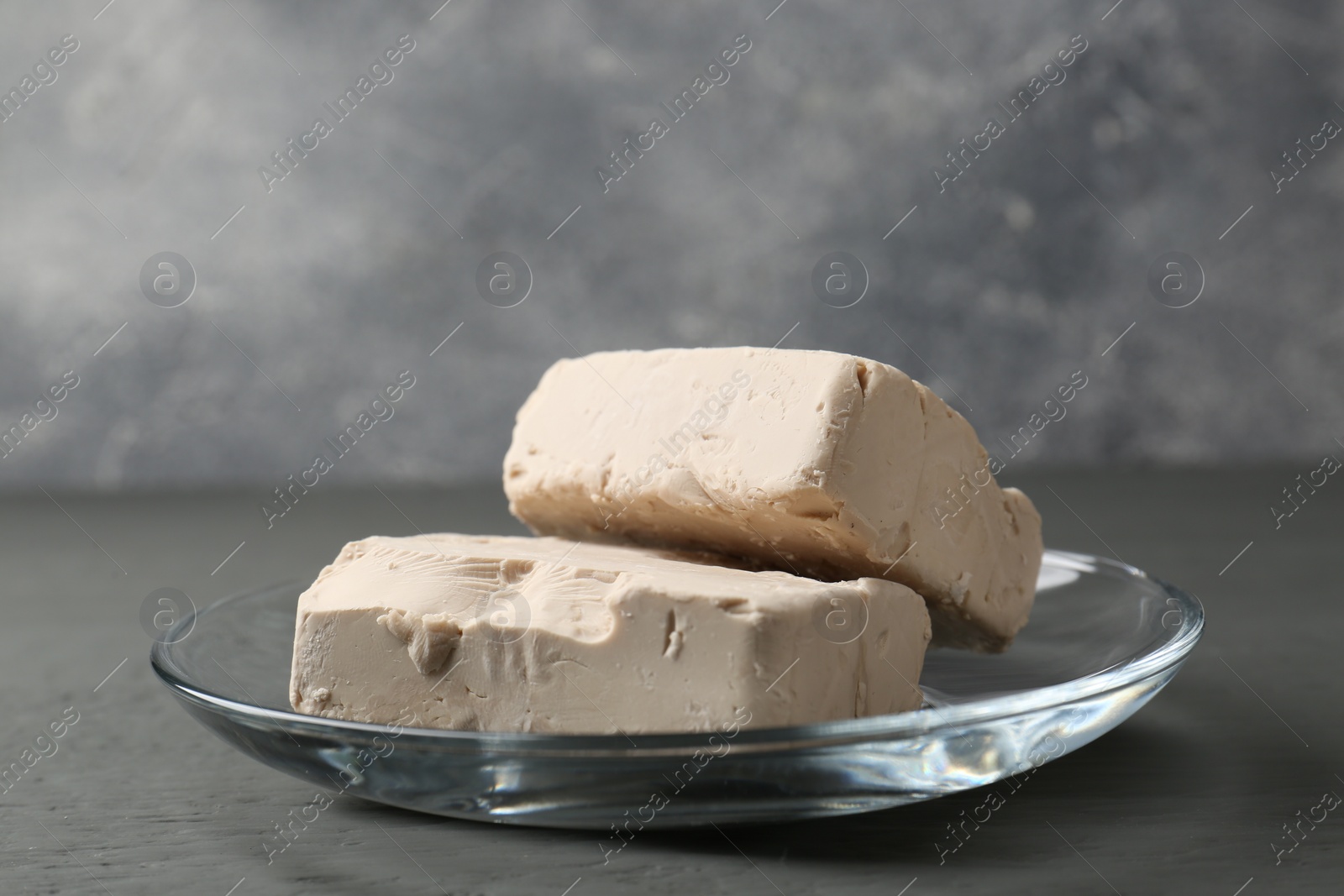 Photo of Fresh compressed yeast on grey wooden table